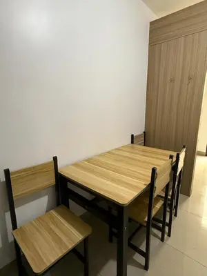 a wooden table and chairs in a room at 1 Bedroom Shore Residences 2 For Rent in Manila