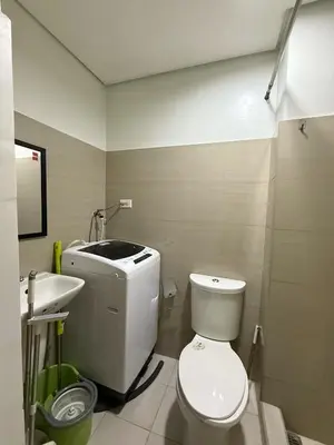 a bathroom with a white toilet and a sink at 1 Bedroom Shore Residences 2 For Rent in Manila