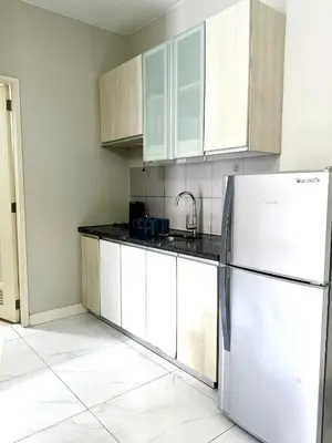 a kitchen with white cabinets and a refrigerator at WP1102 Facing pool view near MOA in Manila