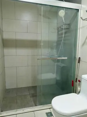 a glass shower in a bathroom with a toilet at WP1102 Facing pool view near MOA in Manila