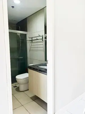 a bathroom with a toilet and a glass shower at WP1102 Facing pool view near MOA in Manila