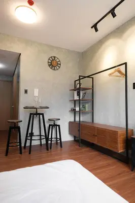 a bedroom with a bed and a table and two stools at SMDC Lush The Forge in Manila