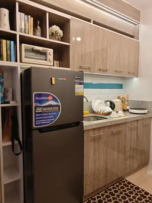 a kitchen with a black refrigerator in a kitchen at Golden Luxe Staycation Studio in Manila