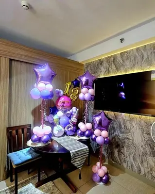 a room with a table with purple and purple balloons at Irene's luscious place in Manila