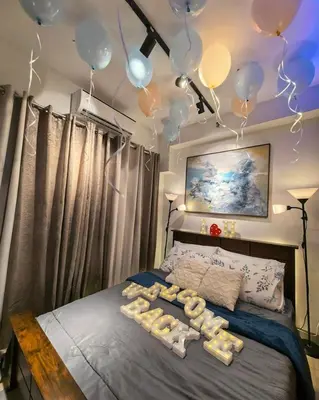 a room with a bed with balloons on it at Irene's luscious place in Manila