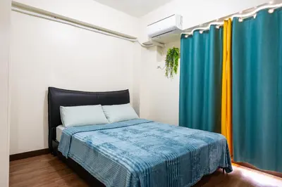 a bedroom with a bed and curtains in a room at fairlane 1bed room in Manila