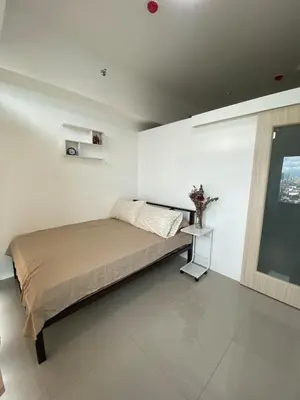 a white bedroom with a bed and a window at Modern Minimalist City Views in Prime Location in Manila