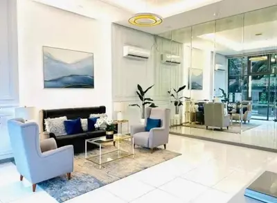 a living room with a couch and chairs and a table at Modern Minimalist City Views in Prime Location in Manila