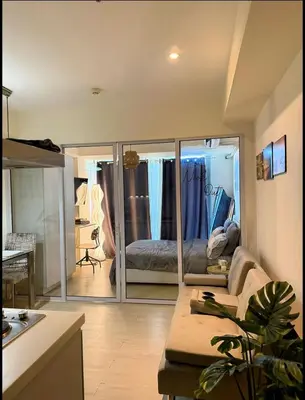 a living room with a bed and a large mirror at Nook Out at Azure Urban Residences in Manila