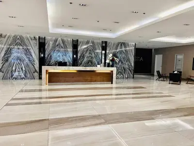 a lobby with a reception desk and paintings on the walls at Near SM MOA in Manila