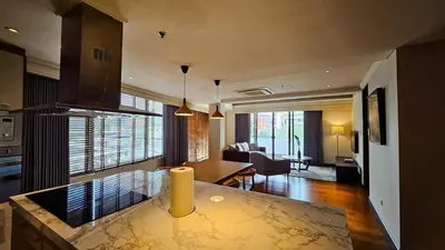 a kitchen with a table and a living room at 2 Bedroom Urban Oasis Poblacion in Manila