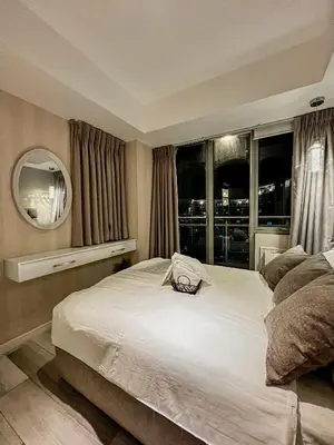 a bedroom with a large bed and a mirror at La Luana Mnl in Manila