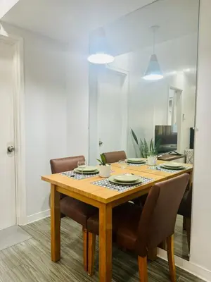 a dining room with a wooden table and chairs at Cozy Haven in Manila
