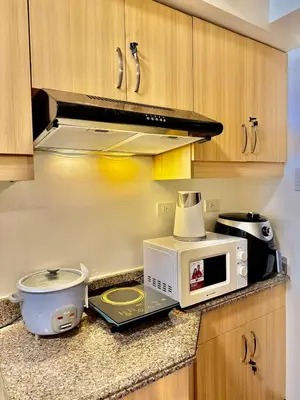 a kitchen with a microwave and a slow cooker on a counter at YourSafeHaven Calathea Place Lavender Bldg in Manila
