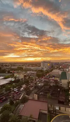 a city with traffic on a street at sunset at YourSafeHaven Calathea Place Lavender Bldg in Manila
