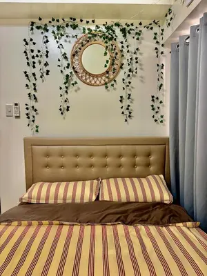 a bedroom with a bed with flowers on the wall at YourSafeHaven Calathea Place Lavender Bldg in Manila