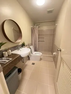 a bathroom with a sink and a toilet and a mirror at Aesthetic Cozy Modern Condo Apartment in Manila