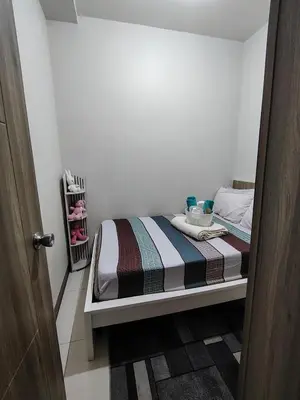 a small bedroom with a bed in a room at Condotel-Coast Residences in Manila