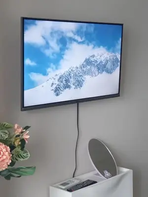 a flat screen tv on a wall with a remote control at Condotel-Coast Residences in Manila