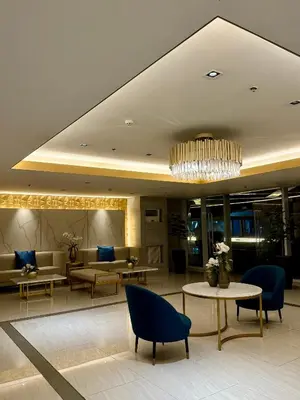 a lobby with chairs and tables and a chandelier at Tres Casa in Manila