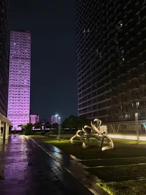 a sculpture in a park at night with tall buildings at Tres Casa in Manila