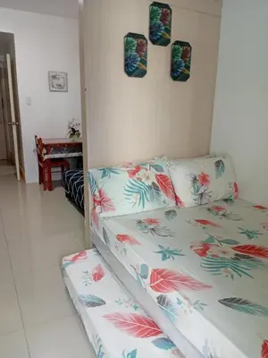 a bed in a room with avertisement for at Rdhee Condotel NEAR SMX MOA in Manila