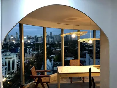a dining room with a view of a city at 55-SQM The Urban Cabin in Poblacion Makati in Manila