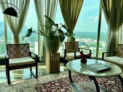 a living room with a table and chairs and a large window at 55-SQM Urban Cabin in Poblacion Makati in Manila
