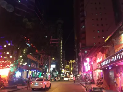 a car driving down a city street at night at 55-SQM Stunning View Wood House Poblacion Makati in Manila