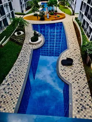 a swimming pool with blue water in a building at Hotel De Rama Unit 5115 near MOA and NAIA in Manila
