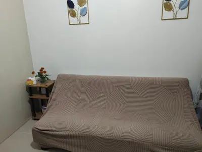 a couch sitting in a living room next to a table at Sea Residences, Pkwy, Pasay City 1300, Philippines in Manila