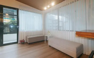 a living room with a couch and a window at RedDoorz at Zenova Hotel in Manila