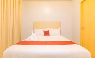 a bedroom with a bed with a stuffed animal on it at RedDoorz at Zenova Hotel in Manila