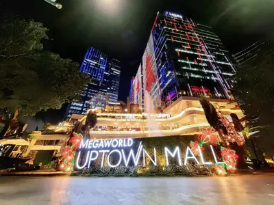 a building with a sign that reads metropolitan uptown mall at night at Stylish 1BR Prime BGC Uptown near Hyatt #upt119c in Manila