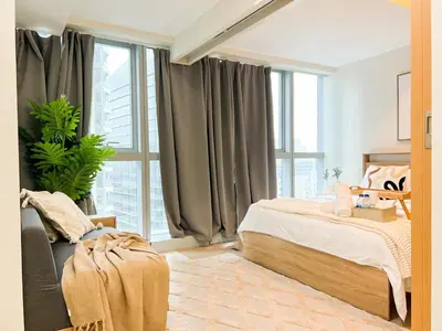a bedroom with a bed and a large window at Stylish 1BR Prime BGC Uptown near Hyatt #upt119c in Manila