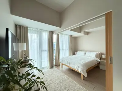 a bedroom with a bed and a large window at Uptown Suites in Manila