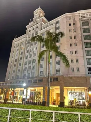 a large building with a palm tree in front of it at Jentry condotel in Manila