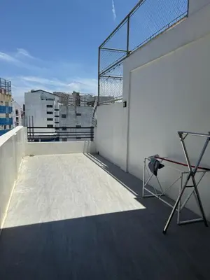 a balcony with a table on top of a building at 4 stores with rooftop in Manila