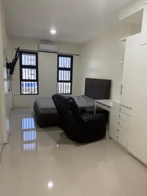 a bedroom with a bed and a chair and a desk at 4 stores with rooftop in Manila