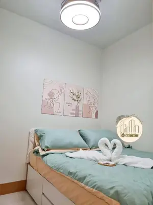 a bedroom with a bed with two towels on it at EcityStay in Manila