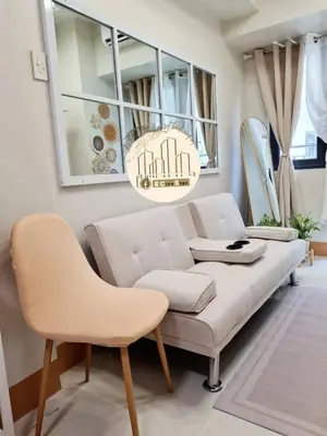 a living room with a white couch and a chandelier at EcityStay in Manila