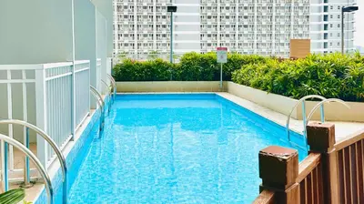 a swimming pool on the roof of a building at Cozy accommodation near MOA AIRPORT WORLD TRADE AND PICC in Manila