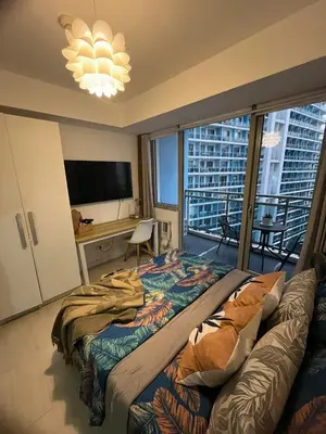 a bedroom with a bed and a desk and a television at Azure Bali Verde-1Bedroom pool view in Manila