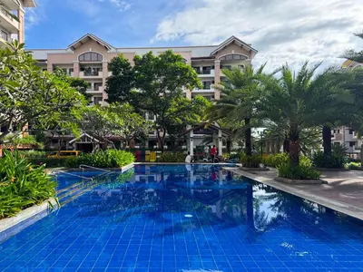 a swimming pool in front of a hotel at Boutique one-bedroom apartment near airport, business hubs in Manila