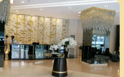 a lobby with a table and flowers in a building at Vistaro Stays at Fame Residences in Manila