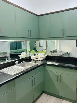 a kitchen with green cabinets and a sink at Apartment in Parañaque in Manila