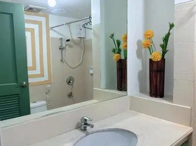 a bathroom with a sink and two vases with flowers at Apartment in Parañaque in Manila