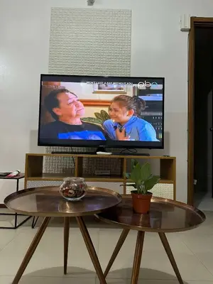 a large flat screen tv sitting in a living room at Circulo verde in Manila