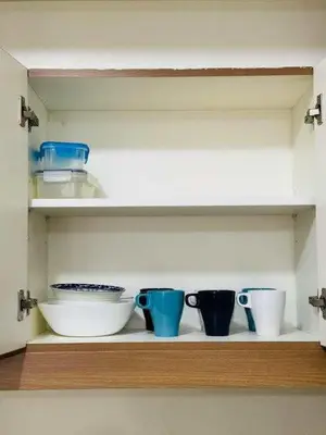 a shelf with some bowls and cups on it at Vtan Condo in Manila