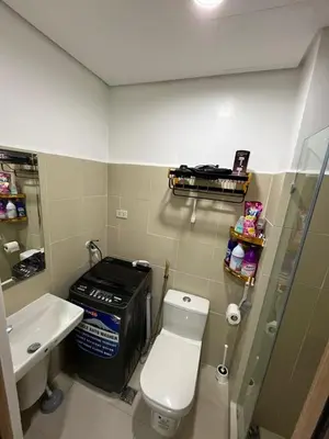 a small bathroom with a toilet and a sink at Lush Residence in Manila